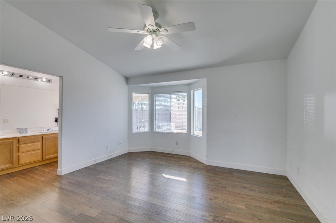 6543 Mahogany Peak Avenue, Las Vegas, NV 89110 Hardwood floors and a deep bay window accent this spacious primary bedroom suite.