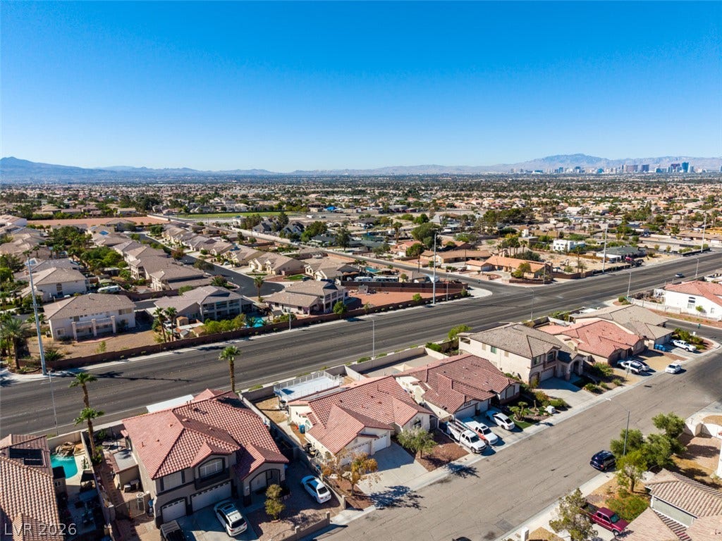 6543 Mahogany Peak Avenue, Las Vegas, NV 89110 Distant mountains frame the surrounding neighborhood and city skyline under a clear blue sky.