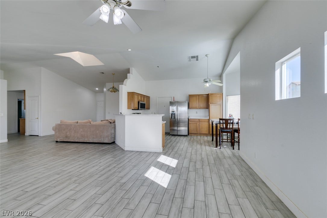 6543 Mahogany Peak Avenue, Las Vegas, NV 89110 Gleaming tile floors stretch across a light-filled open layout connecting the kitchen and living areas.