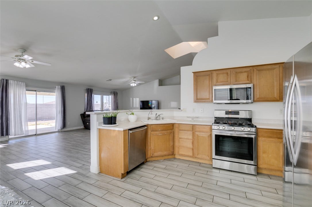 6543 Mahogany Peak Avenue, Las Vegas, NV 89110 Gleaming tile floors unite this airy, open-concept kitchen and adjacent living area.