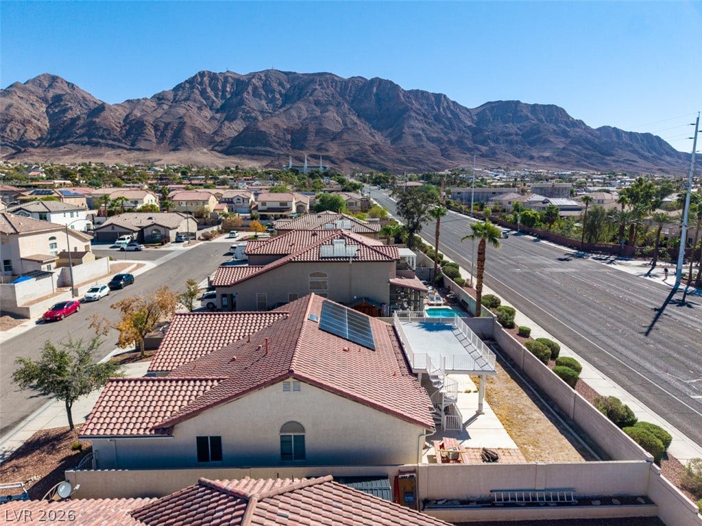 6543 Mahogany Peak Avenue, Las Vegas, NV 89110 A dramatic mountain backdrop frames this residential neighborhood with tile roofs and solar panels.