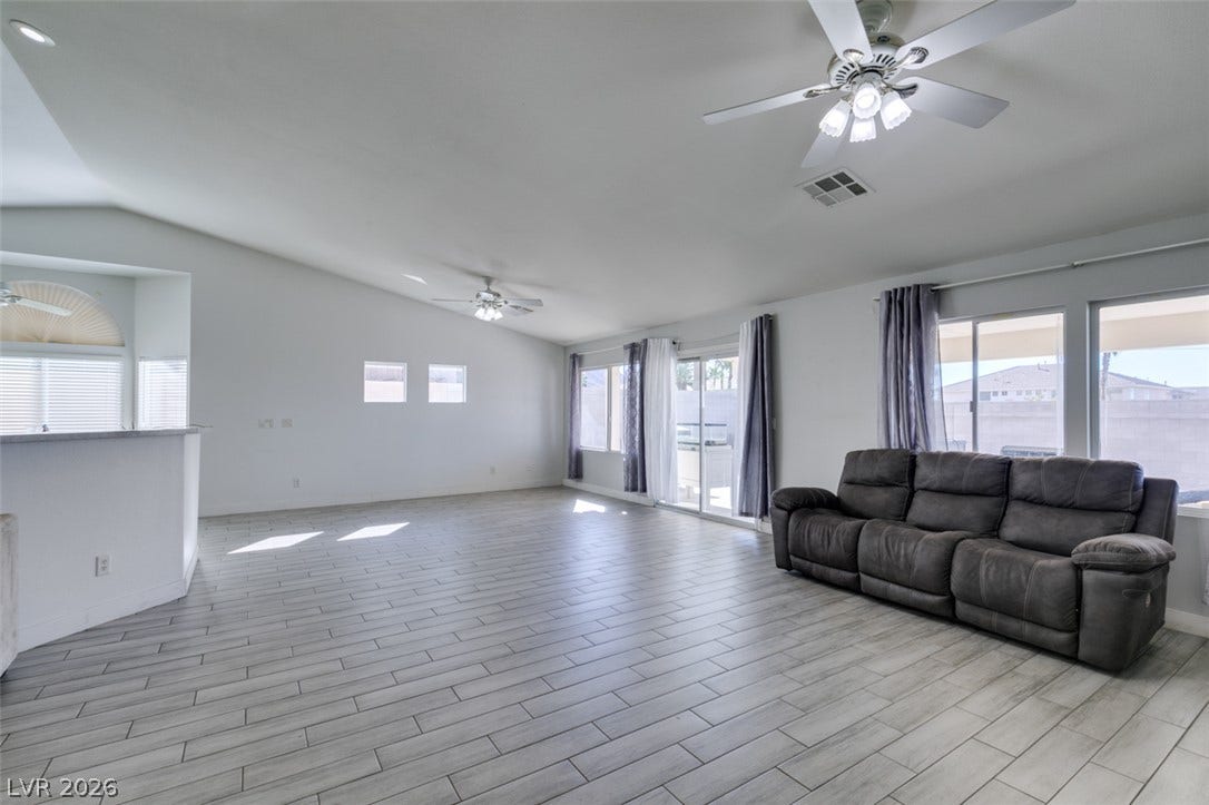 6543 Mahogany Peak Avenue, Las Vegas, NV 89110 An open living space features durable tile flooring, vaulted ceilings, and sliding glass doors.