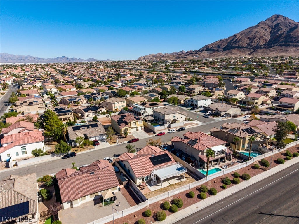 6543 Mahogany Peak Avenue, Las Vegas, NV 89110 An expansive neighborhood vista unfolds beneath clear blue skies and majestic mountain backdrops.