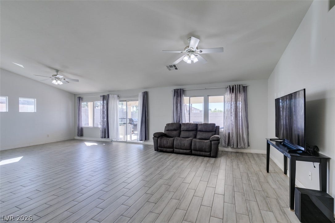 6543 Mahogany Peak Avenue, Las Vegas, NV 89110 An open living space features durable tile flooring and sliding glass doors to the backyard.