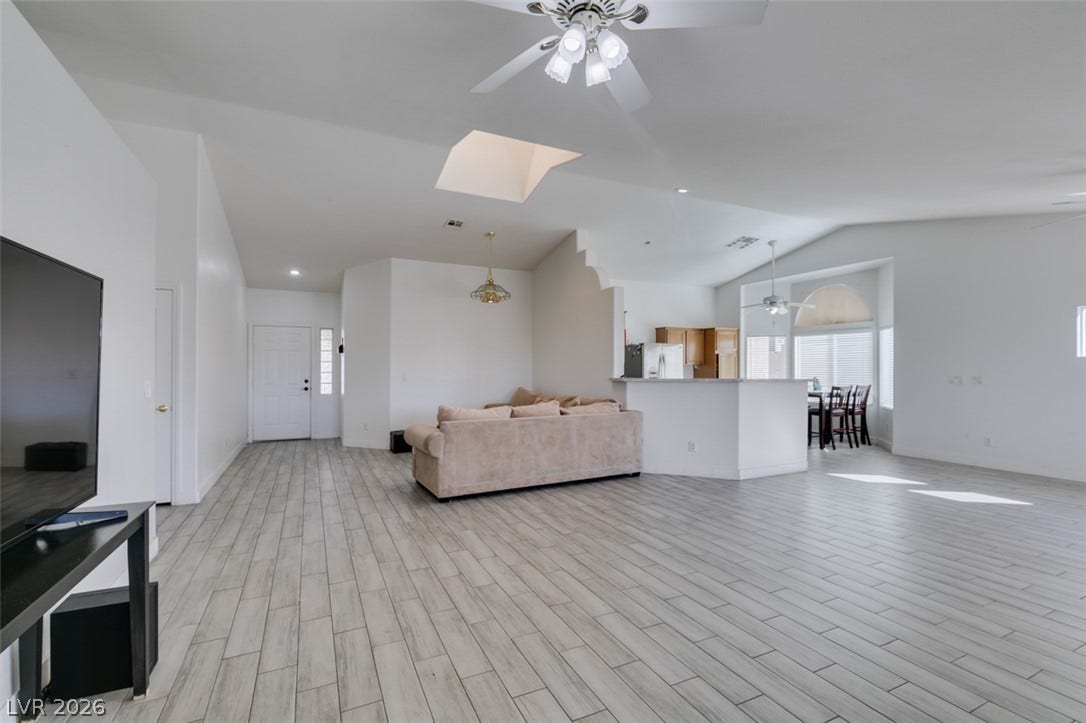 6543 Mahogany Peak Avenue, Las Vegas, NV 89110 Gleaming plank flooring sweeps through this airy open-concept living space accented by a skylight.
