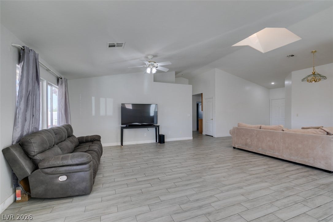 6543 Mahogany Peak Avenue, Las Vegas, NV 89110 An open-concept layout anchors this spacious room with plank flooring and an overhead skylight.