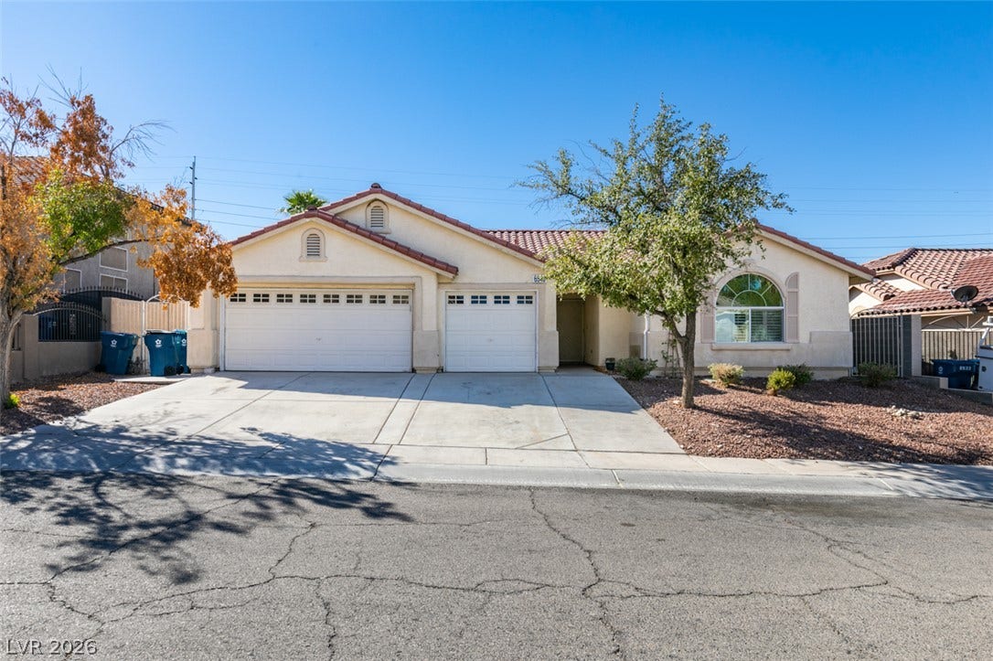 6543 Mahogany Peak Avenue, Las Vegas, NV 89110 A spacious driveway leads to this classic suburban home featuring tile roofing and arched windows.