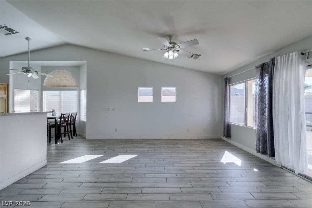 6543 Mahogany Peak Avenue, Las Vegas, NV 89110 Vaulted ceilings and wood-look tile flooring define this airy living space with sliding glass door access.