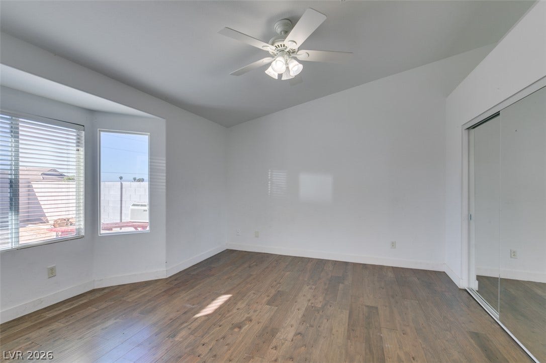 6543 Mahogany Peak Avenue, Las Vegas, NV 89110 Vaulted ceilings and rich wood-plank flooring define this airy bedroom space.