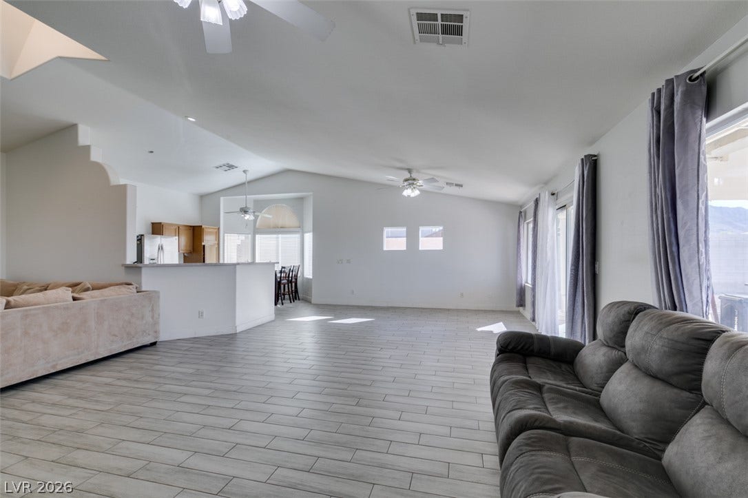 6543 Mahogany Peak Avenue, Las Vegas, NV 89110 An open floorplan connects the living area to the kitchen over neutral tile flooring.