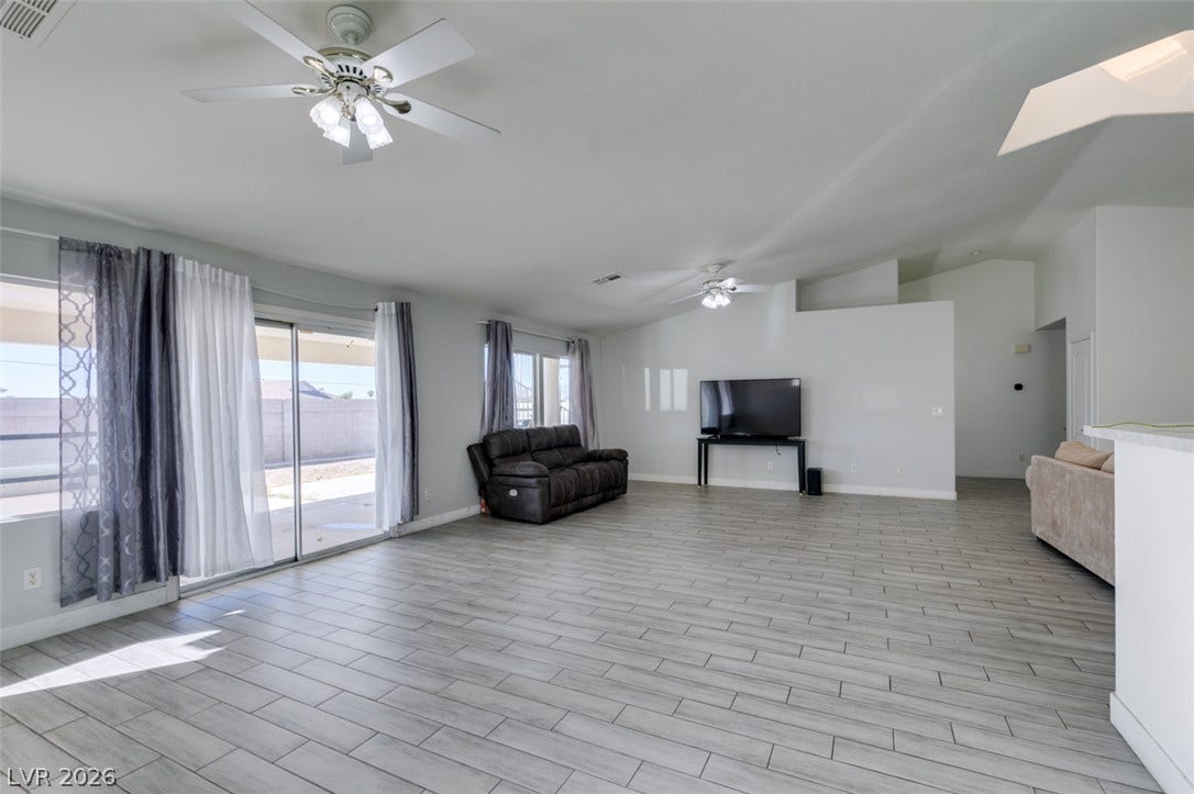 6543 Mahogany Peak Avenue, Las Vegas, NV 89110 Clean modern flooring and sliding glass doors define this airy living space.