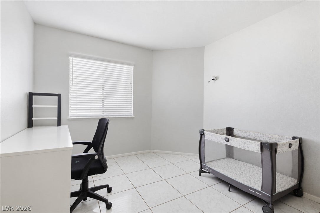 3960 Grapefruit Circle, Las Vegas, NV 89103 Crisp white walls and tile flooring define this versatile secondary bedroom space.
