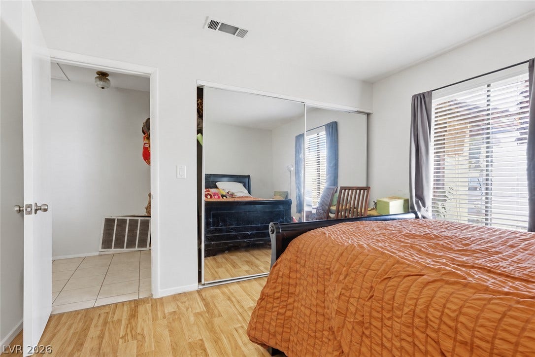 3960 Grapefruit Circle, Las Vegas, NV 89103 Warm wood flooring and mirrored closets enhance this cozy bedroom space.