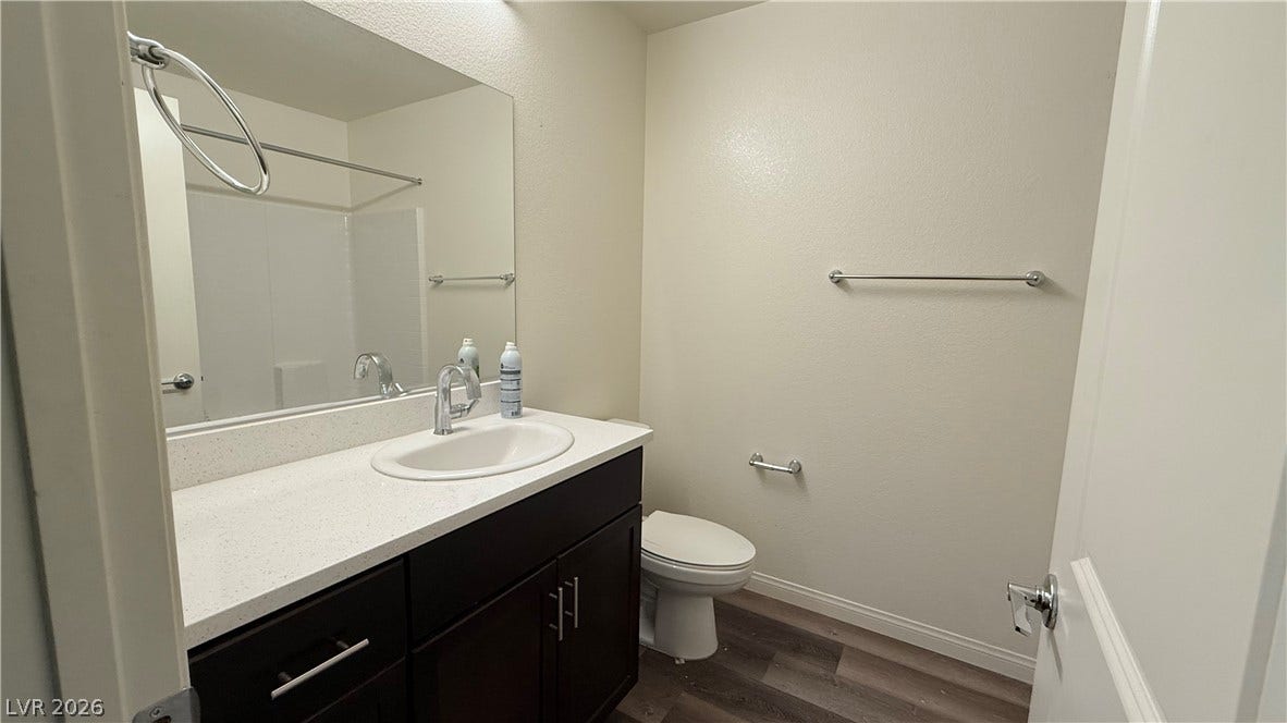 10079 Vibrant Moon Avenue, Las Vegas, NV 89129 Clean lines and a dark wood vanity anchor this functional, modern bathroom design.
