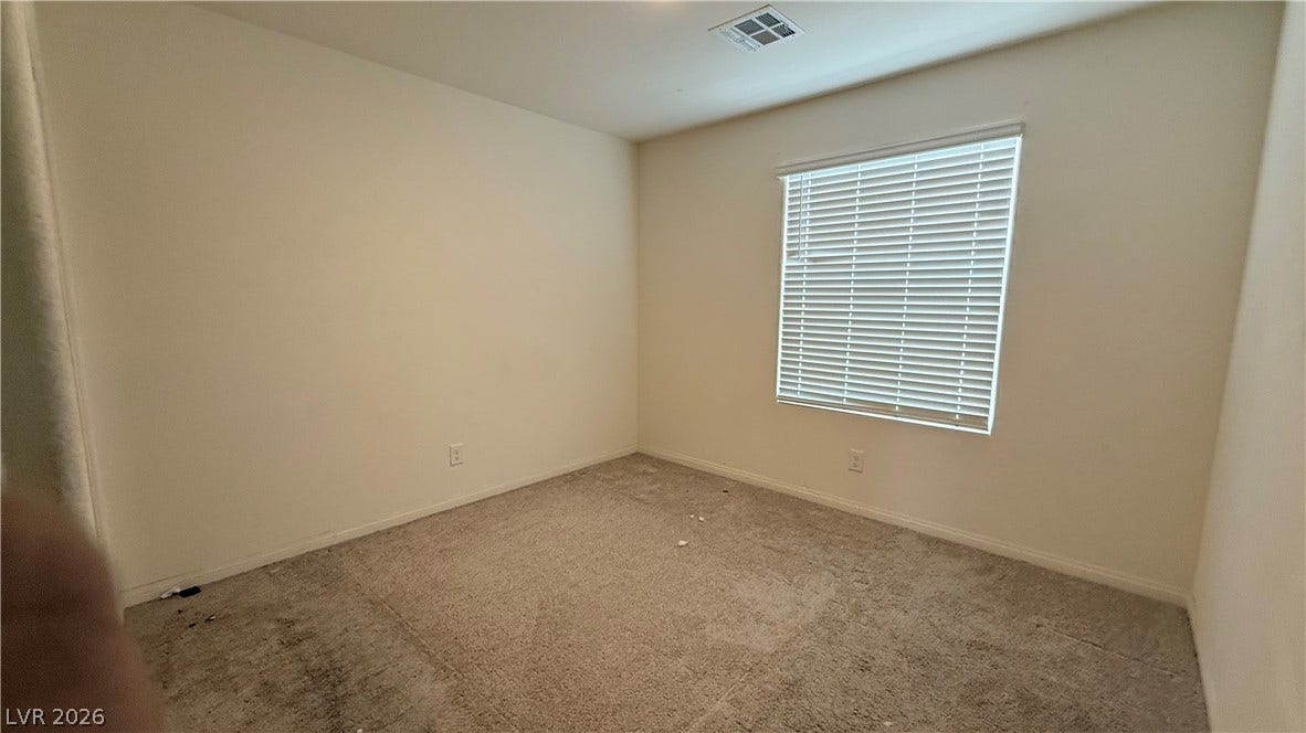 10079 Vibrant Moon Avenue, Las Vegas, NV 89129 Carpeted floors and a large window frame this versatile secondary bedroom space.