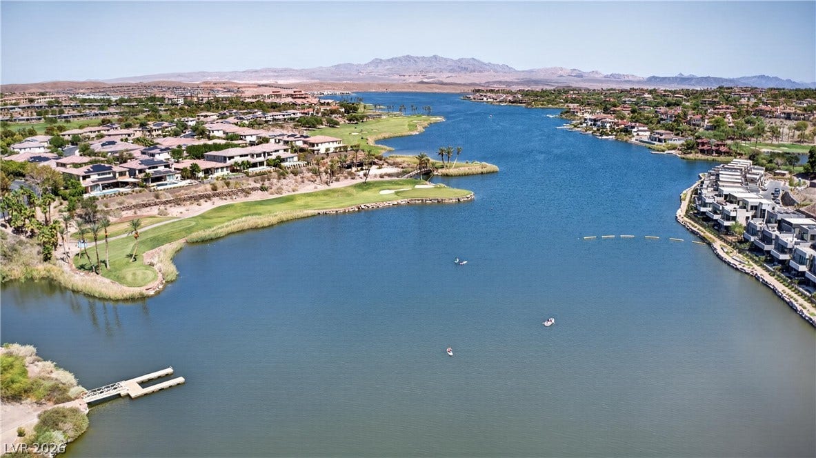 4 Bobado Lane, Henderson, NV 89011 Breathtaking desert mountains frame a wide, blue lake winding through a lakeside golf community.