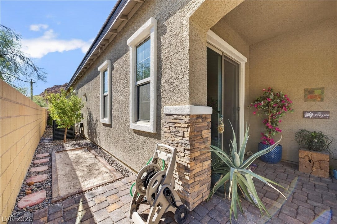 4 Bobado Lane, Henderson, NV 89011 Textured stucco walls and stacked stone accents line a paved side walkway and covered patio.