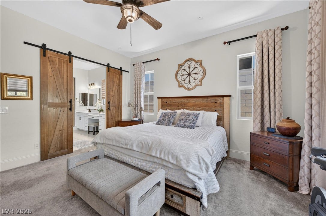 4 Bobado Lane, Henderson, NV 89011 Double sliding barn doors open to reveal an adjacent master bathroom from this bedroom.
