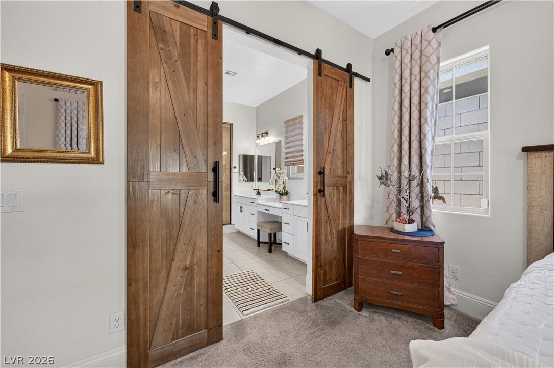 4 Bobado Lane, Henderson, NV 89011 Double sliding barn doors open to reveal an adjacent master bathroom with dual vanities.
