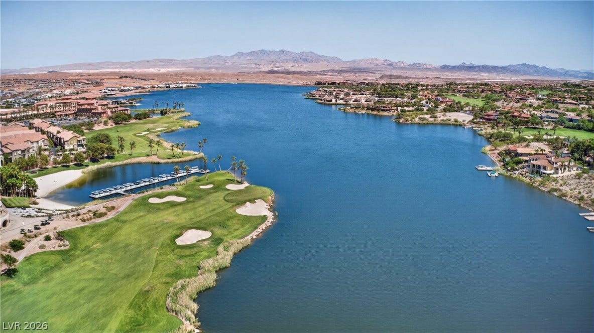 4 Bobado Lane, Henderson, NV 89011 A deep blue lake anchors this desert landscape alongside a lush green golf course.