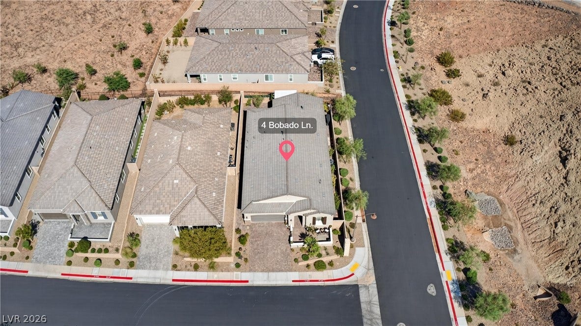 4 Bobado Lane, Henderson, NV 89011 An aerial perspective showcases a modern neighborhood setting with tile-roofed residences along paved streets.