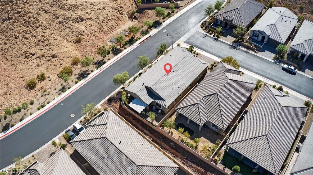4 Bobado Lane, Henderson, NV 89011 A high-angle view reveals tiled rooftops and paved streets within a modern hillside community.