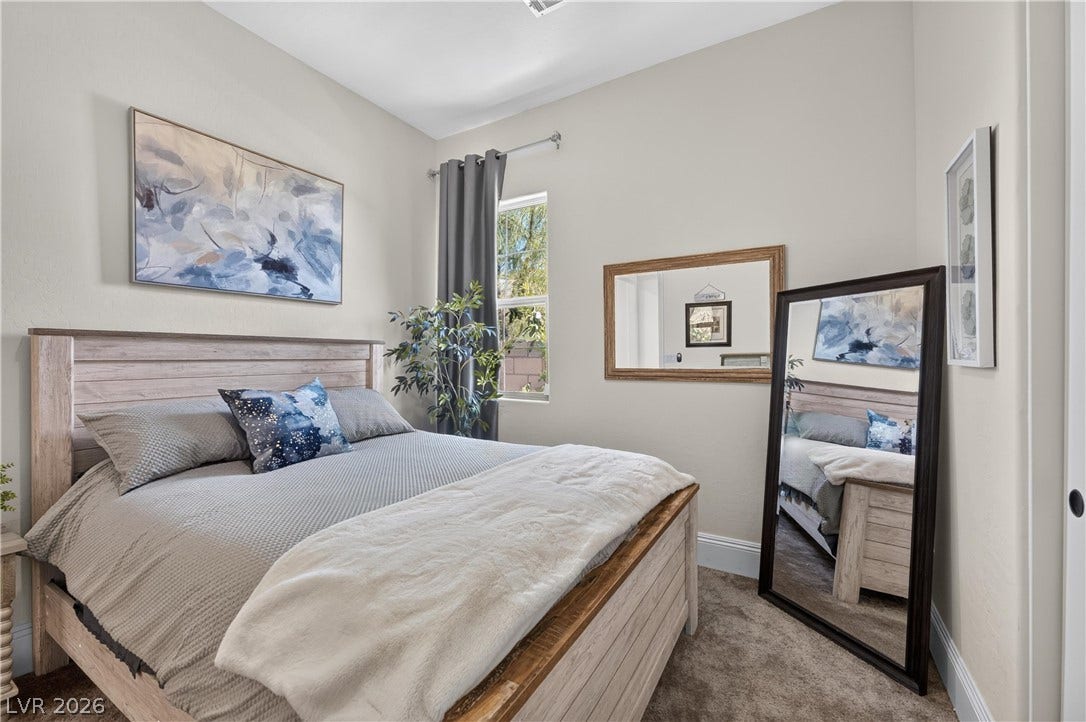 4 Bobado Lane, Henderson, NV 89011 A tall window welcomes natural light across carpeted flooring in this tranquil bedroom.