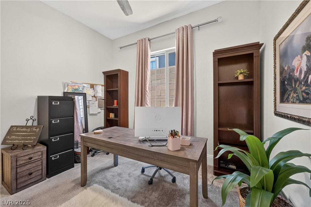4 Bobado Lane, Henderson, NV 89011 A quiet home office features plush carpeting and a central window overlooking the property.