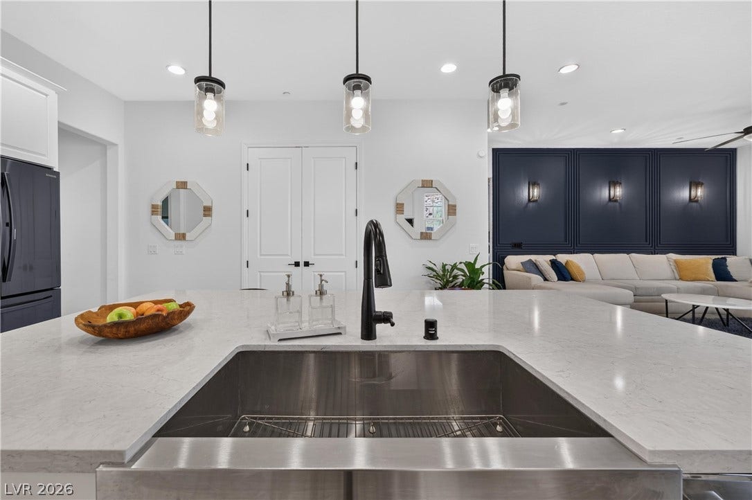 4 Bobado Lane, Henderson, NV 89011 An open floorplan seamlessly connects the stone-countertop kitchen island to the main living area.