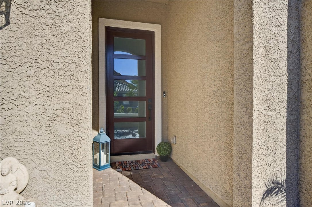 4 Bobado Lane, Henderson, NV 89011 An inviting entryway features textured stucco walls and a handsome glass-paneled front door.
