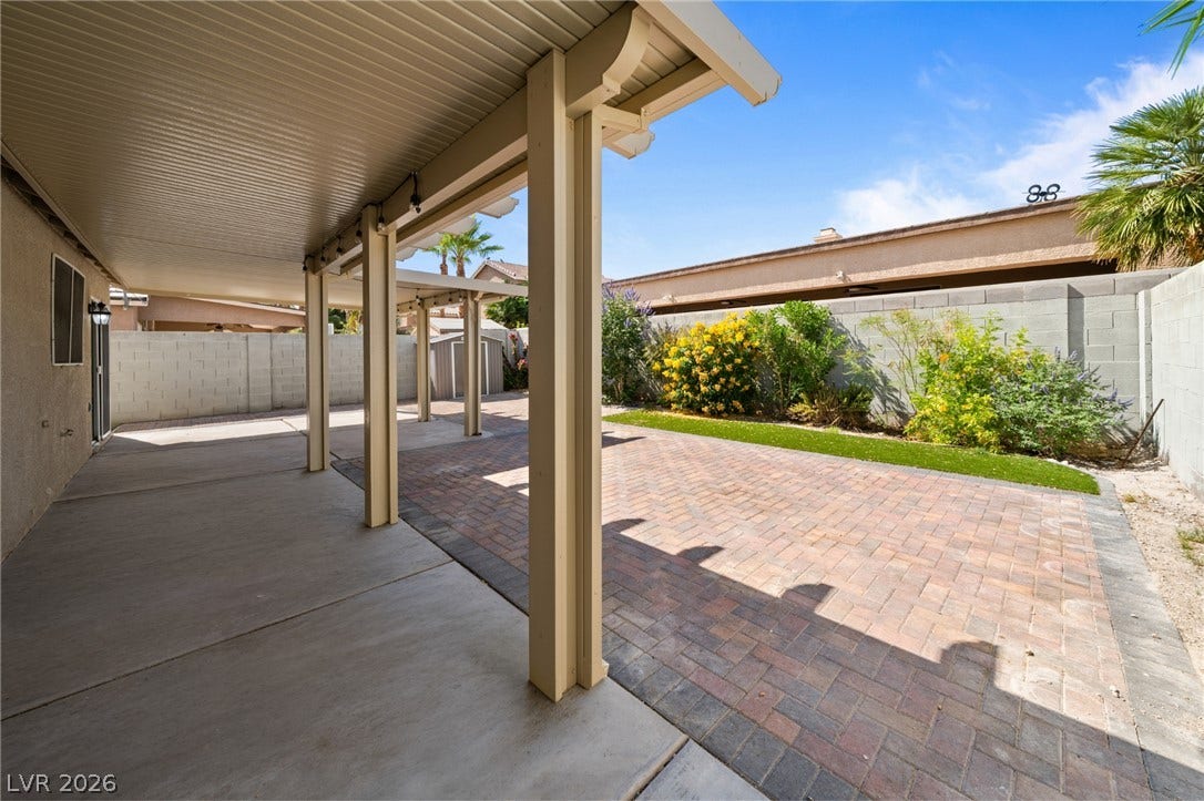 A spacious covered patio transitions seamlessly to a low-maintenance paver courtyard and private yard.