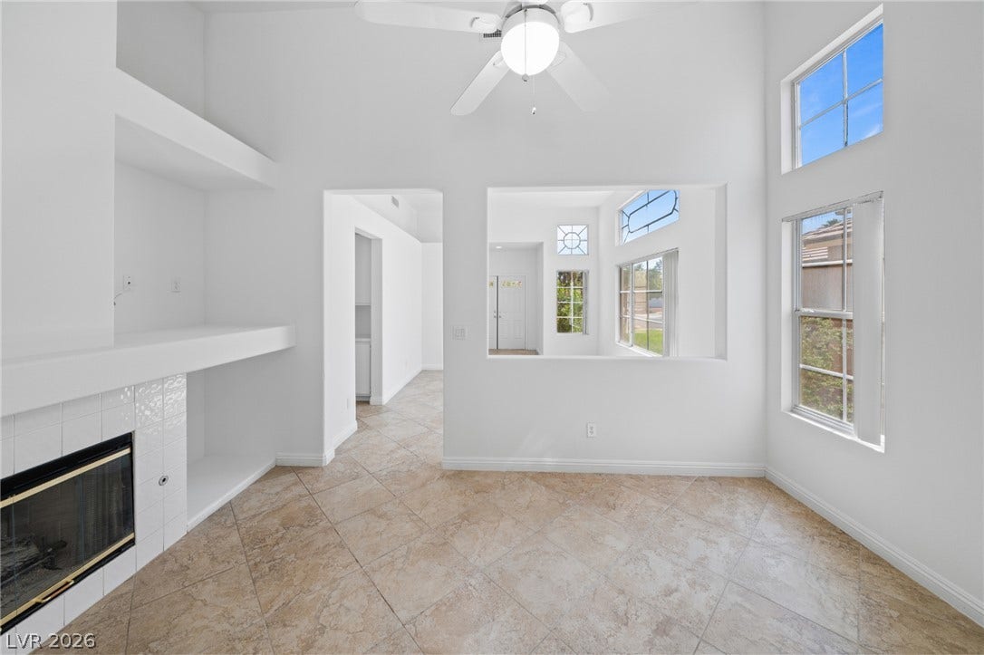 Vaulted ceilings and tile flooring create an airy atmosphere around the cozy fireplace.
