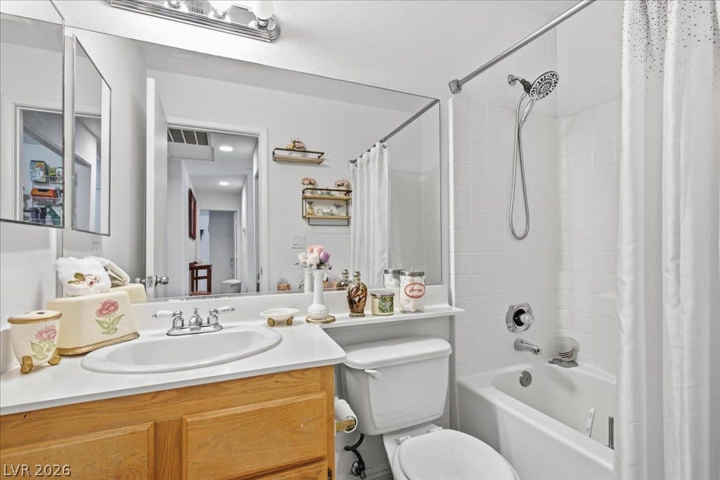 White tiled tub surround paired with a wood vanity brings classic character to this bathroom.