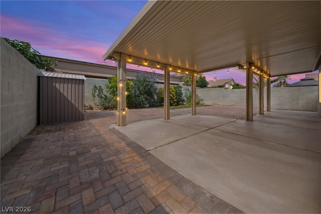 A spacious covered patio sits adjacent to a brick paver courtyard and private yard.