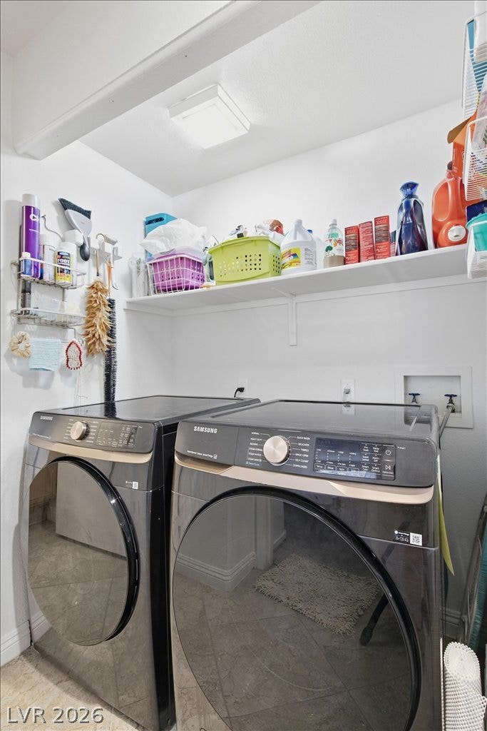 A functional laundry area features overhead storage shelving and durable tile flooring.