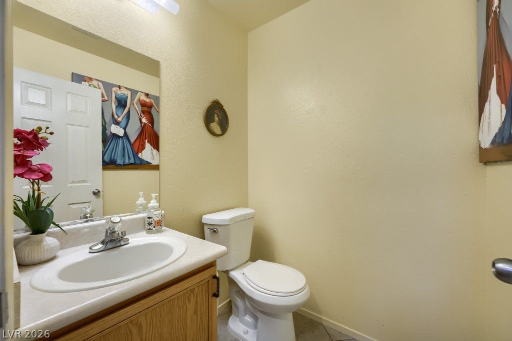 2099 Lost Maple Street, Las Vegas, NV 89115 An inviting powder room features a classic vanity alongside durable tile flooring.