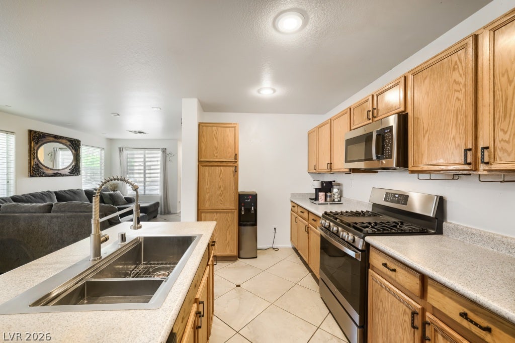 2099 Lost Maple Street, Las Vegas, NV 89115 Warm wood cabinetry and neutral tile floors define this functional kitchen layout.