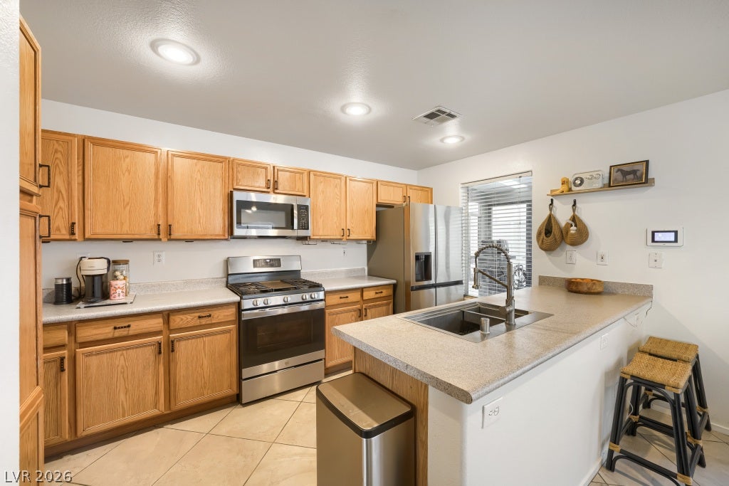 2099 Lost Maple Street, Las Vegas, NV 89115 Warm oak cabinetry pairs with ceramic tile flooring in this classic, functional kitchen.