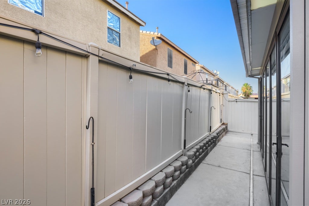 2099 Lost Maple Street, Las Vegas, NV 89115 A private concrete side yard walkway is lined with vinyl fencing and sliding glass doors.