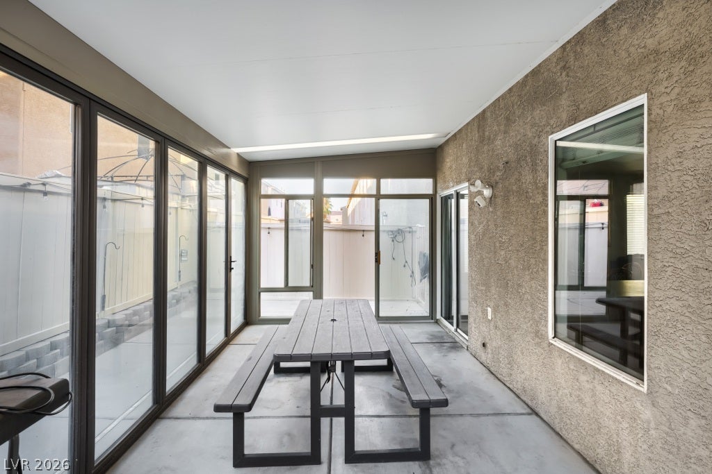 2099 Lost Maple Street, Las Vegas, NV 89115 An enclosed sunroom provides a versatile space featuring concrete flooring and stucco walls.