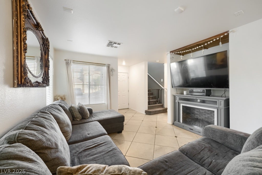 2099 Lost Maple Street, Las Vegas, NV 89115 Tiled flooring and a fireplace mantle create a comfortable setting in this modern living room.