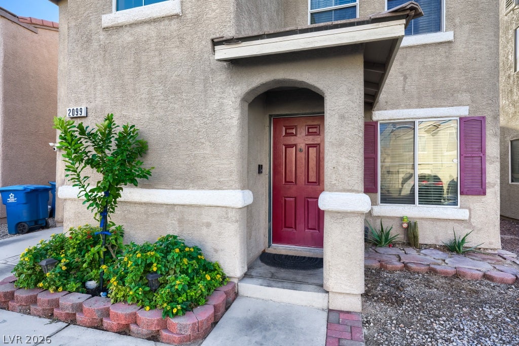 2099 Lost Maple Street, Las Vegas, NV 89115 A welcoming arched entryway leads to the front door of this modern stucco home.
