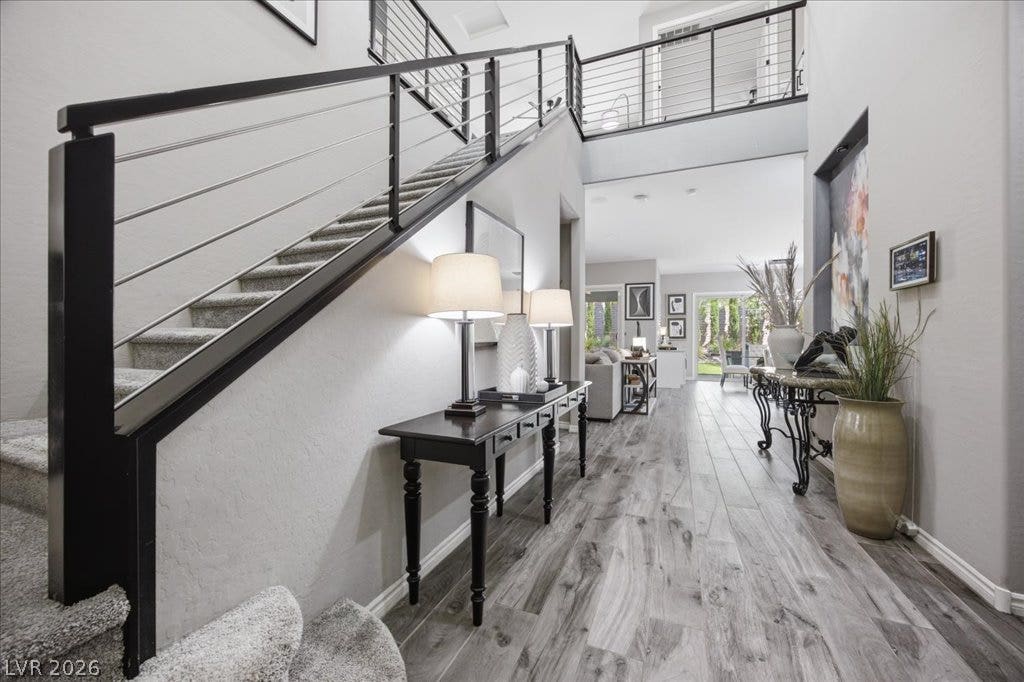 181 Elder View Drive, Las Vegas, NV 89138 Modern cable railings flank the staircase in this airy entryway with wood-look flooring.