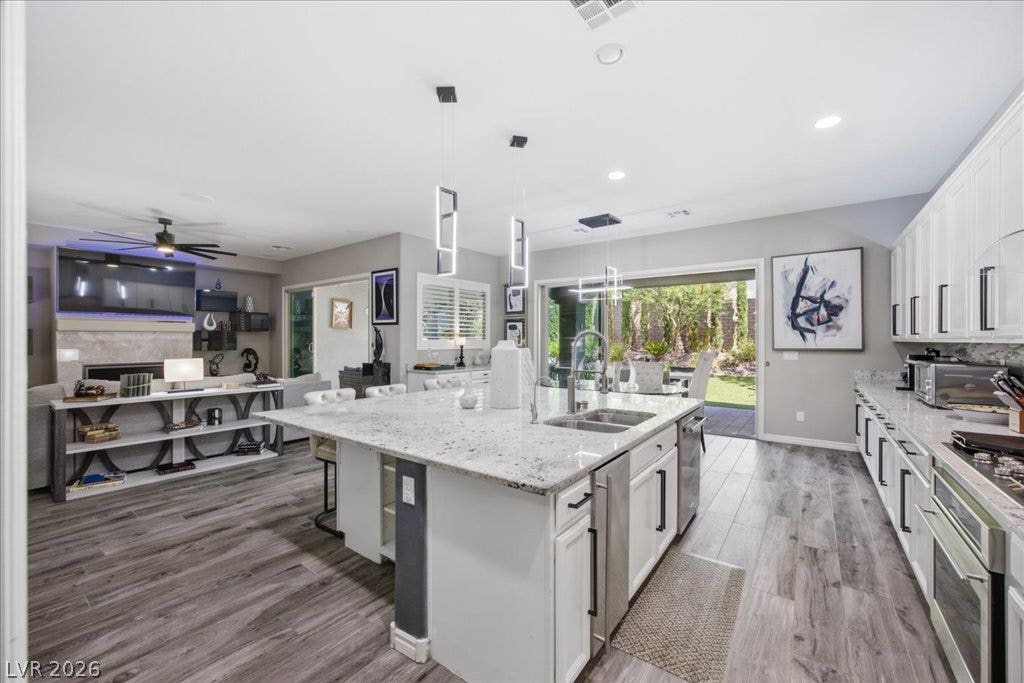 181 Elder View Drive, Las Vegas, NV 89138 An open floorplan seamlessly connects the stone-countertop kitchen to the adjacent living spaces.