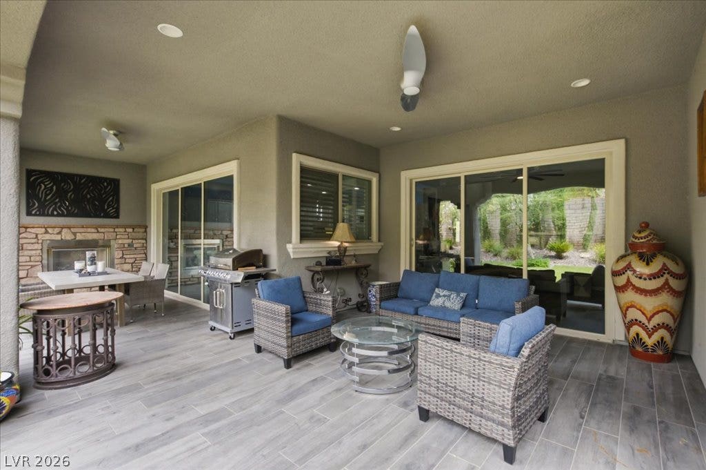 181 Elder View Drive, Las Vegas, NV 89138 An inviting outdoor living space features a built-in fireplace, a barbecue area, and comfortable seating.