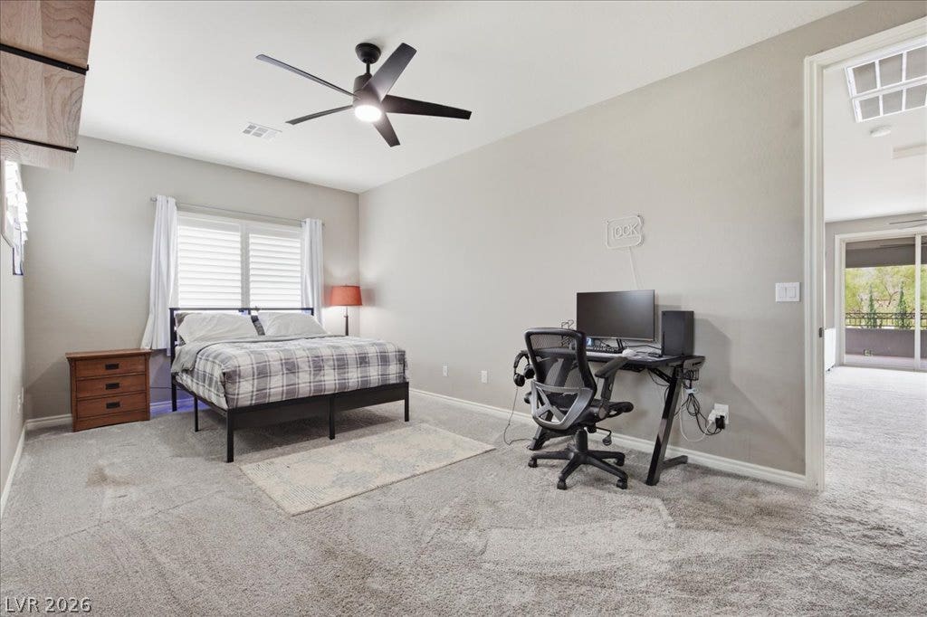 181 Elder View Drive, Las Vegas, NV 89138 Comfortable bedroom with carpeted floors offers ample space for rest and a dedicated workspace.