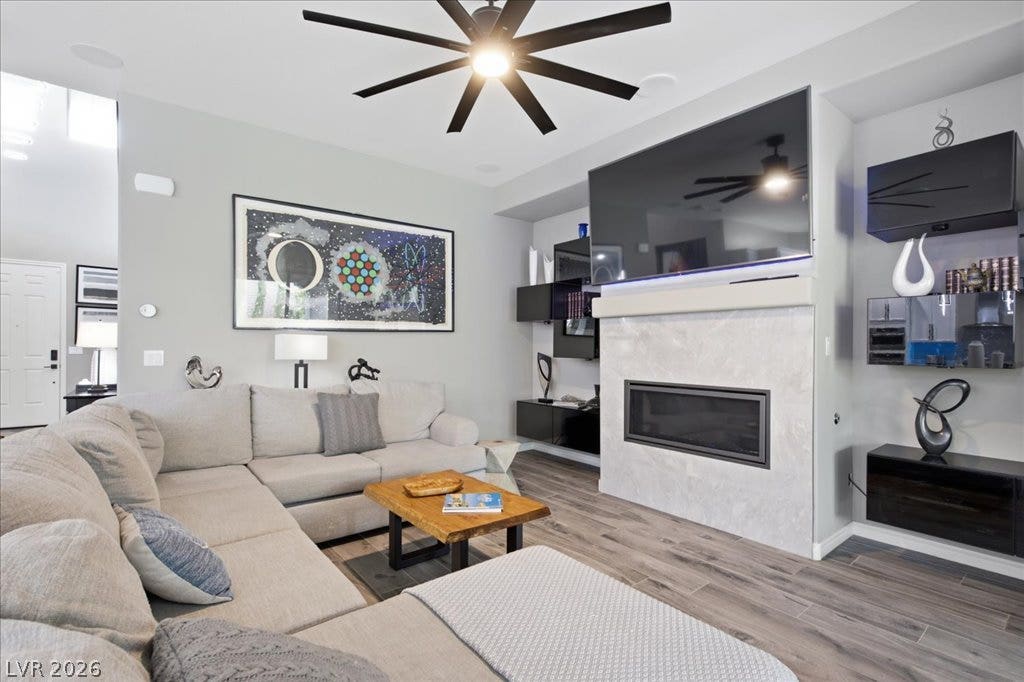 181 Elder View Drive, Las Vegas, NV 89138 A comfortable living area features a modern fireplace and a large ceiling fan for ultimate relaxation.