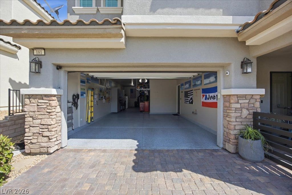 181 Elder View Drive, Las Vegas, NV 89138 An inviting stone-accented exterior frames the entrance to a pristine and spacious garage.