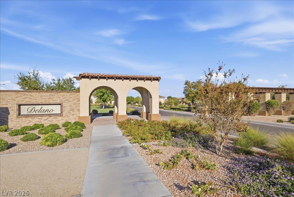 181 Elder View Drive, Las Vegas, NV 89138 A concrete walkway leads through an arched entryway flanked by neat desert landscaping.
