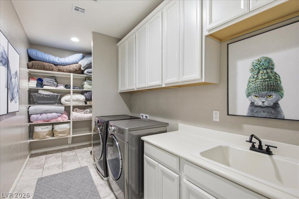 181 Elder View Drive, Las Vegas, NV 89138 Functional laundry space featuring ample shelving, practical sink, and modern appliances for efficient chores.